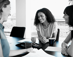 Female employee reviewing onboarding materials during first day at work, seated at desk with HR documents and welcome kit.
