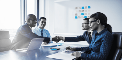 Executives in a quiet meeting—where system design decisions shape workplace culture behind the scenes.