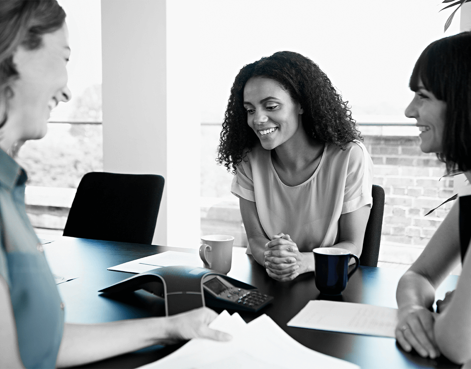 Female employee reviewing onboarding materials during first day at work, seated at desk with HR documents and welcome kit.